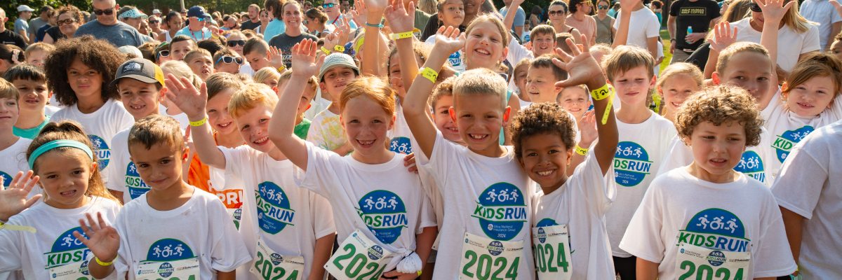Kids Smiling and waving at the Kids Run race starting line.