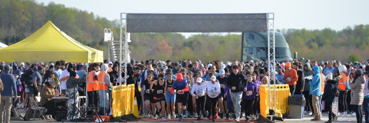 Hundreds of runners head out at the start of the PTI 5k/10k Run on the Runway