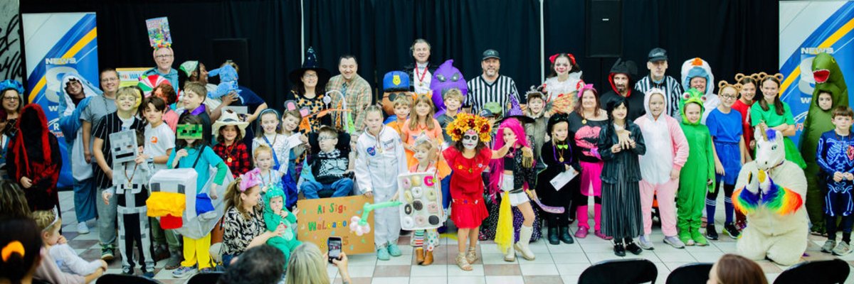 Group of people of all ages dressed in different Halloween costumes