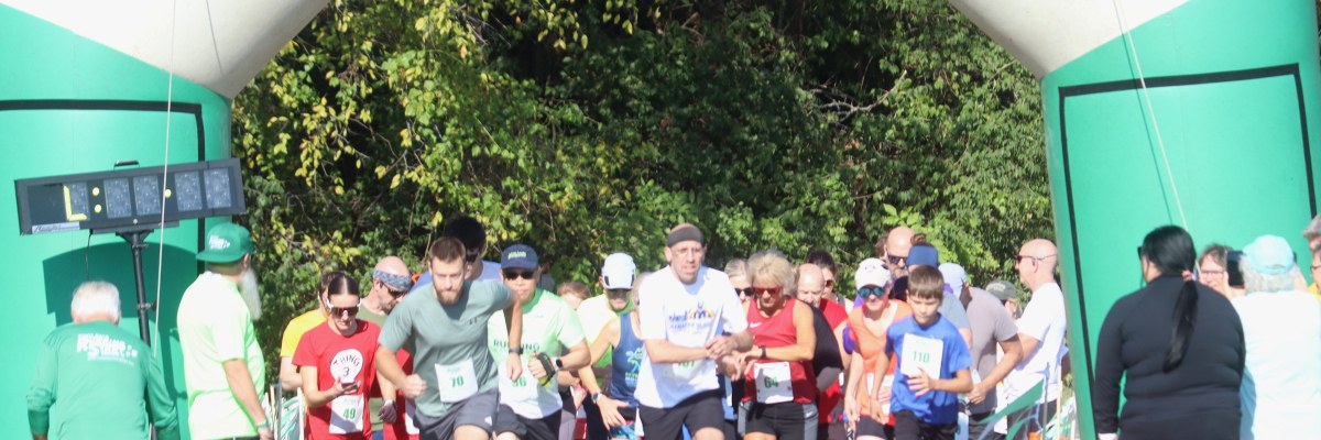 Runners beginning the Sarcoma Stomp beneath the race arch at Carlyle Lake.
