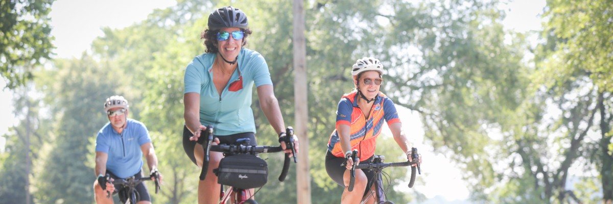 One male and two female cyclists, all smiling