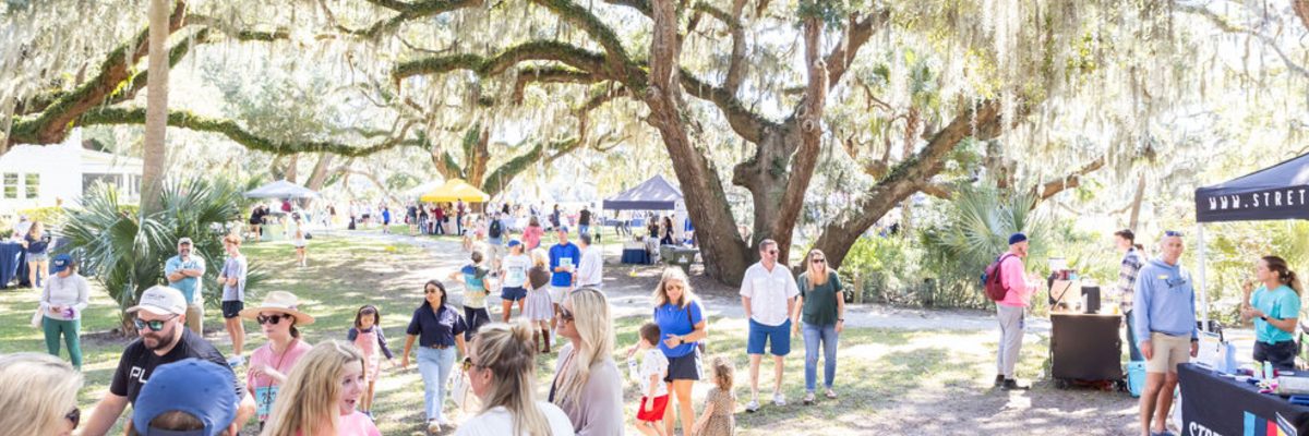Wide view of the vendor village and free fall festival festivities at Kiawah River, with attendees gathered throughout the event area